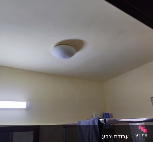 תקרה צבועה בצבע בהיר עם מנורה עגולה